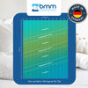 Eine Tabelle mit Größe und Gewicht sowie eingezeichneten Übergangsbereichen die dabei helfen soll, den richtigen Härtegrad für sich zu finden, Darüber das Logo von BMM sowie rechts daneben das Siegel Made in Germany. Im Hintergrund Kissen und Bettdecke sowie einer Vase
