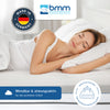 Eine Frau schläft entspannt auf der Seite auf einer weißen Matratze. Im Bild sind das Logo der Brandenburger Matratzen Manufaktur (BMM) und das Siegel ‚Made in Germany‘ zu sehen. Text: ‚Wendbar & atmungsaktiv – für den perfekten Schlaf‘ sowie ein Symbol mit der Aufschrift ‚Sehr hohe Festigkeit – für angenehm hartes Schlafen‘.“